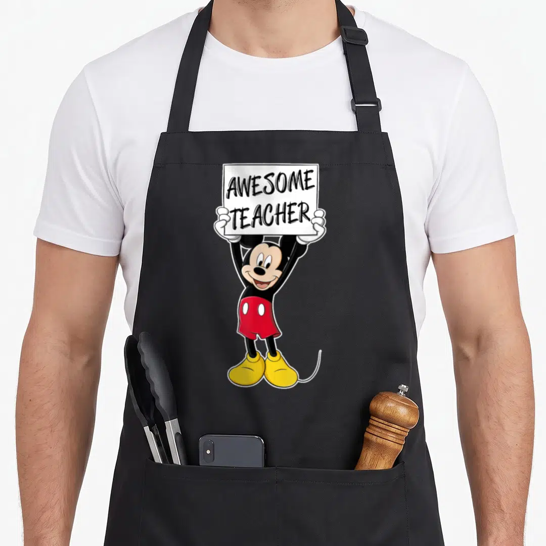Friend teacher apron - Mickey Mouse standing holding white sign with AWESOME TEACHER text — shown on a black cotton canvas apron against a white background