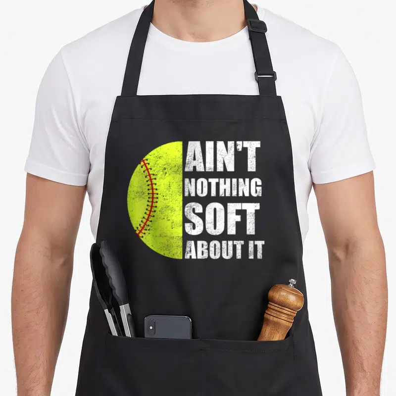 Softball play apron - Neon yellow half-ball with red stitches and stacked white distressed text — shown on a black cotton canvas apron against a white background