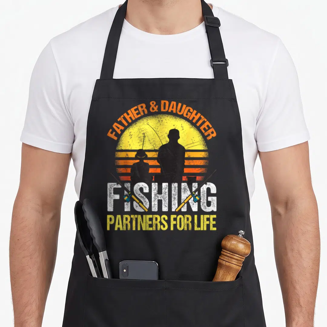Daughter fishing apron - Retro sunset silhouette of father and daughter fishing with crossing rods and Partners — shown on a black cotton canvas apron against a white background