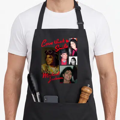 State michaels apron - Collage of four Michael Jackson photos with red Love that Smile text — shown on a black cotton canvas apron against a white background