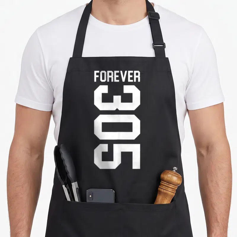Forever florida apron - White stacked text reading FOREVER and 305 in bold block letters — shown on a black cotton canvas apron against a white background