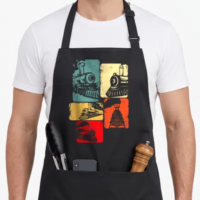Railway engineer apron - Five colored blocks with grey steam locomotive illustrations in retro style — shown on a black cotton canvas apron against a white background