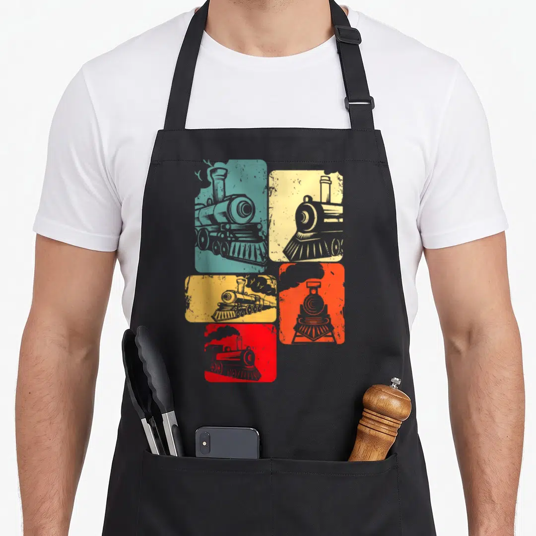 Railway engineer apron - Five colored blocks with grey steam locomotive illustrations in retro style — shown on a black cotton canvas apron against a white background