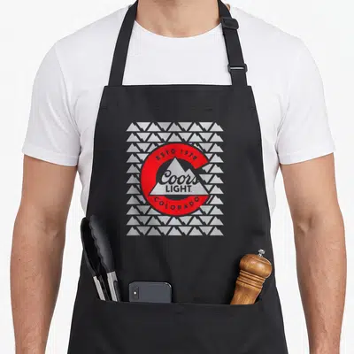 Light beer apron - Red circle with white mountain and Coors Light text over repeating mountain pattern — shown on a black cotton canvas apron against a white background