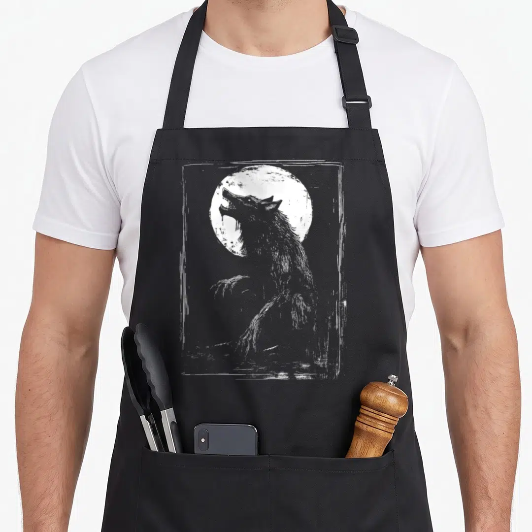 Mythology halloween apron - White wolf howling at a moon inside a distressed rectangular frame in line art style — shown on a black cotton canvas apron against a white background
