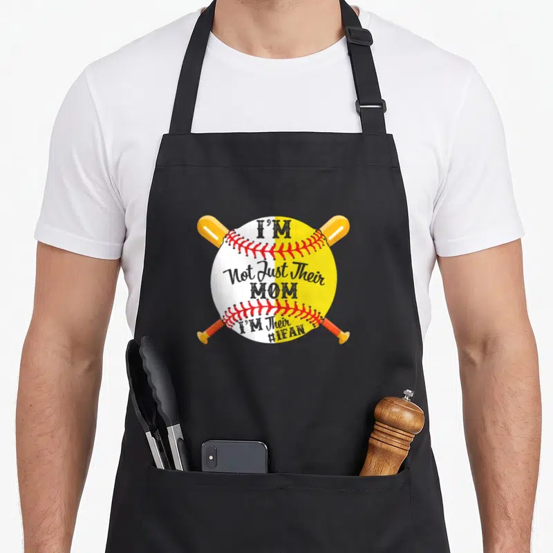 Their baseball apron - Crossed orange and yellow bats behind a split white and yellow baseball with red stitching — shown on a black cotton canvas apron against a white background