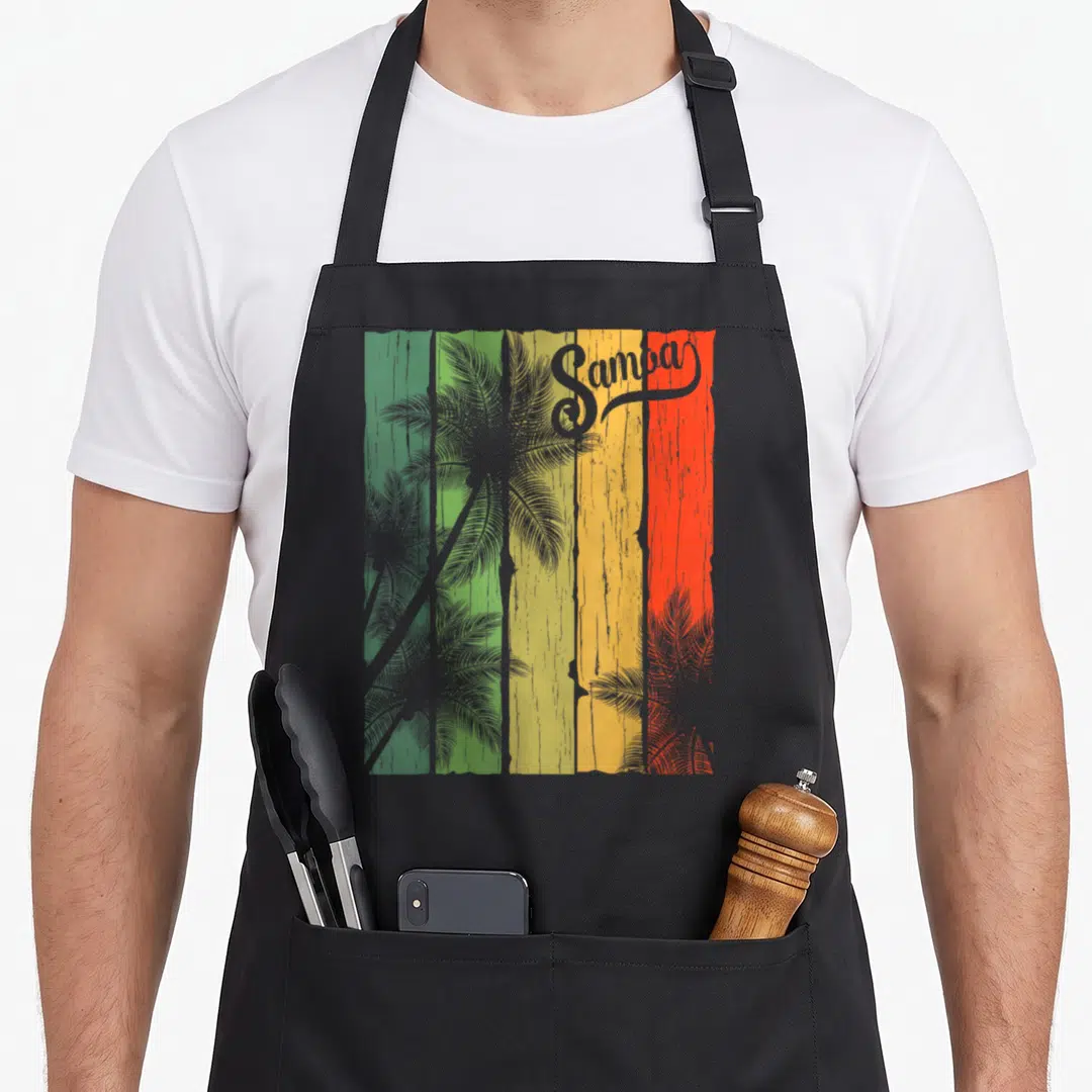 Samoa tree apron - Samba text over grey palm trees on five green yellow orange red stripes — shown on a black cotton canvas apron against a white background