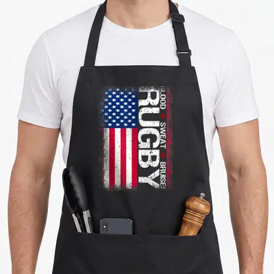 Rugby 4th of july apron - Distressed USA flag with vertical Rugby text and column reading Blood Sweat Bruises separated — shown on a black cotton canvas apron against a white background