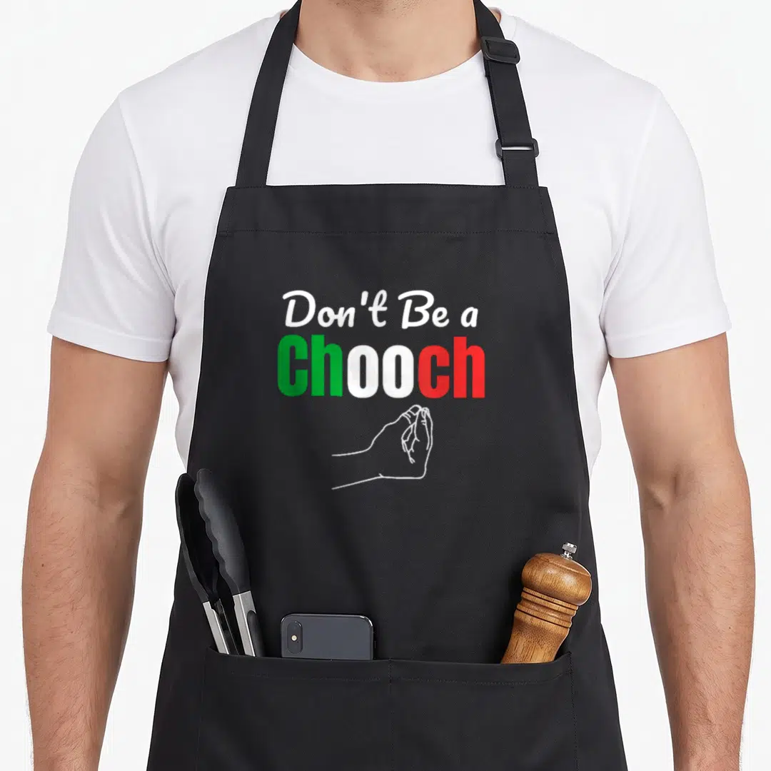 Italian chooch italy apron - Stacked text Don't Be a Chooch with clasped hands line drawing — shown on a black cotton canvas apron against a white background