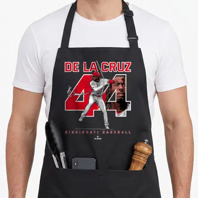 Ballpark baseball apron - De La Cruz name, red 44, batting player, face close-up, Cincinnati Baseball text on grey — shown on a black cotton canvas apron against a white background