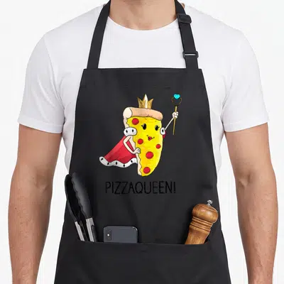 Queen pizza apron - Cartoon pizza slice character with crown red cape scepter and PIZZAQUEEN! text — shown on a black cotton canvas apron against a white background