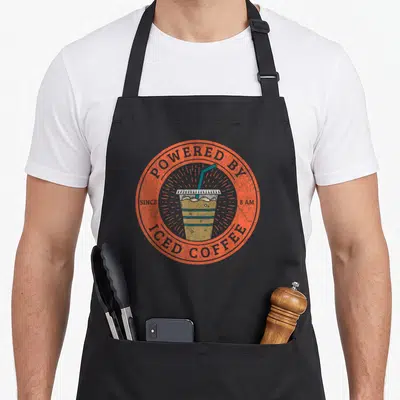 Powered coffee apron - Retro orange circle with iced coffee cup and since 8 am text — shown on a black cotton canvas apron against a white background
