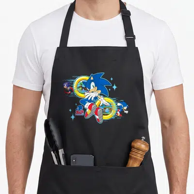 30th crazy hedgehog man apron - Sonic the Hedgehog 30th Anniversary logo with pixel art, gold rings, and blue character — shown on a black cotton canvas apron against a white background