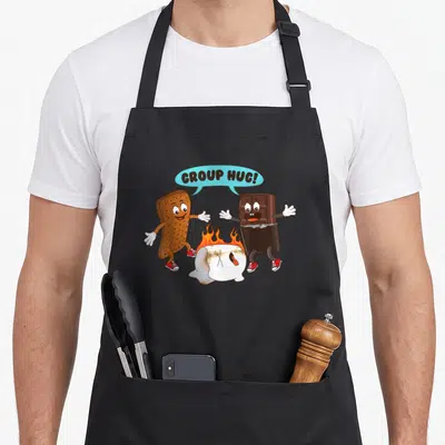 Marshmallow food aprons - Cartoon graham cracker and chocolate reaching for a burning marshmallow under a blue speech — shown on a black cotton canvas apron against a white background