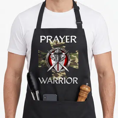 Cross prayer apron - Knight helmet shield and crossed swords on camo cross with PRAYER WARRIOR text — shown on a black cotton canvas apron against a white background