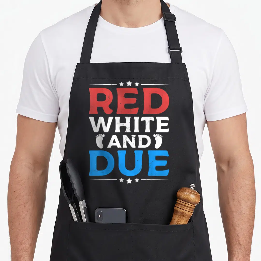 Announcement 4th of july apron - Stacked red white and due text with footprints and stars in distressed style — shown on a black cotton canvas apron against a white background