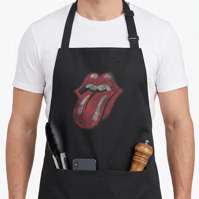 Distressed rolling stones apron - Red and grey distressed mouth with protruding tongue centered on canvas — shown on a black cotton canvas apron against a white background