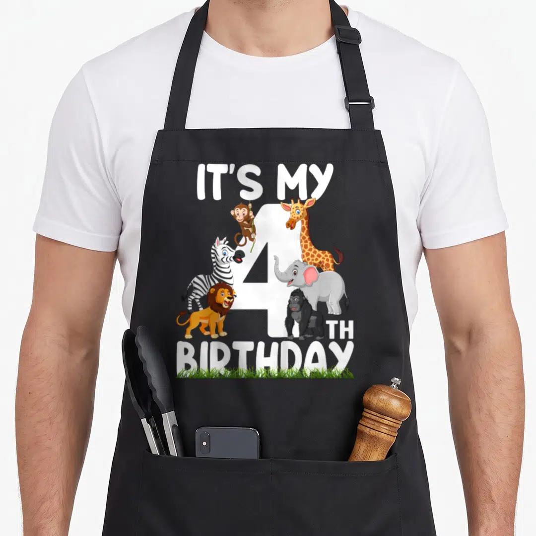 4th zoo birthday apron - Cartoon giraffe elephant zebra lion gorilla monkey around white number 4 with IT'S MY 4TH — shown on a black cotton canvas apron against a white background