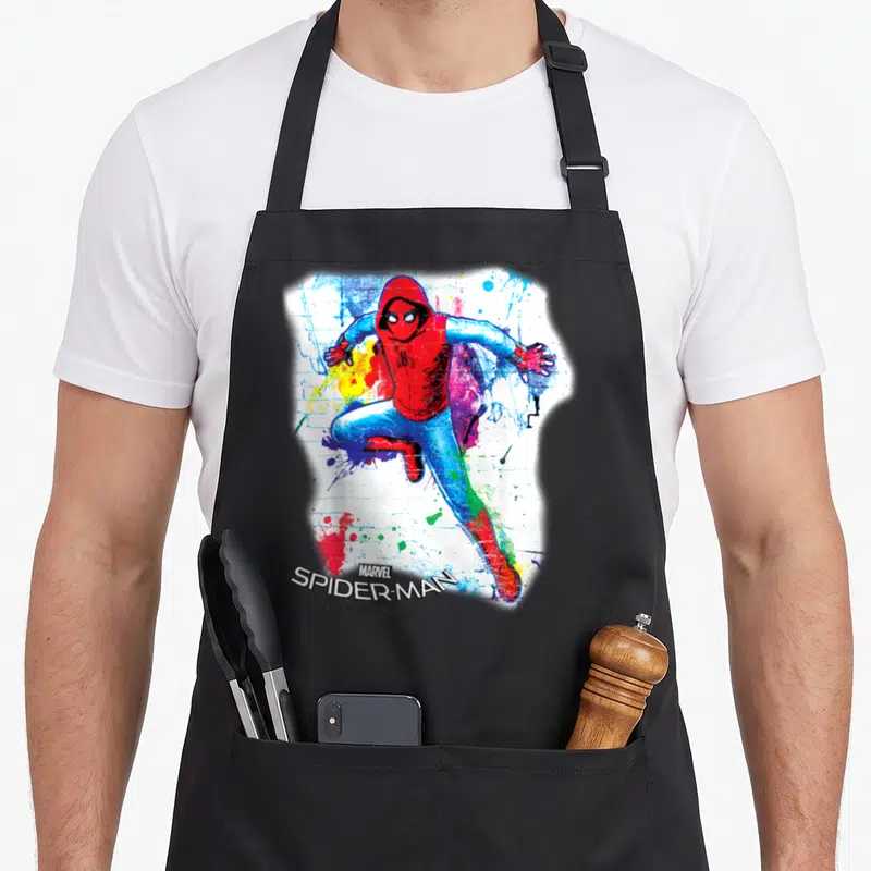 Graffiti homecoming apron - Leaping Spider-Man in red hoodie with watercolor splatters and stacked logo text — shown on a black cotton canvas apron against a white background