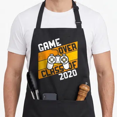 Class video game apron - White game controller over orange stripes with Game Over Class of 2020 text — shown on a black cotton canvas apron against a white background