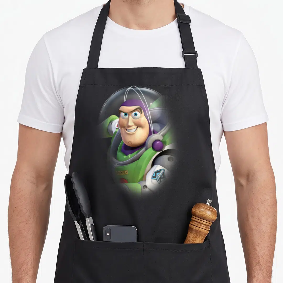 Grin dog breed aprons - Photo of Buzz Lightyear in green suit with LIGHTYEAR text on chest plate — shown on a black cotton canvas apron against a white background