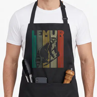 Cool lemur apron - Grey lemur silhouette over vertical stripes of teal, yellow, orange, and red forming the word LEMUR — shown on a black cotton canvas apron against a white background