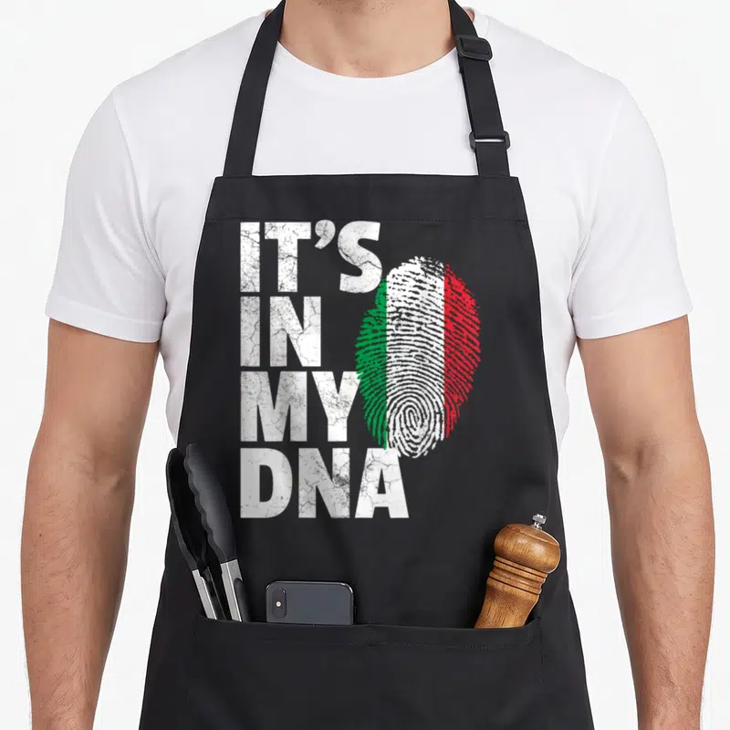 Dna italian aprons - Stacked IT'S IN MY DNA text beside a white green and red distressed fingerprint — shown on a black cotton canvas apron against a white background
