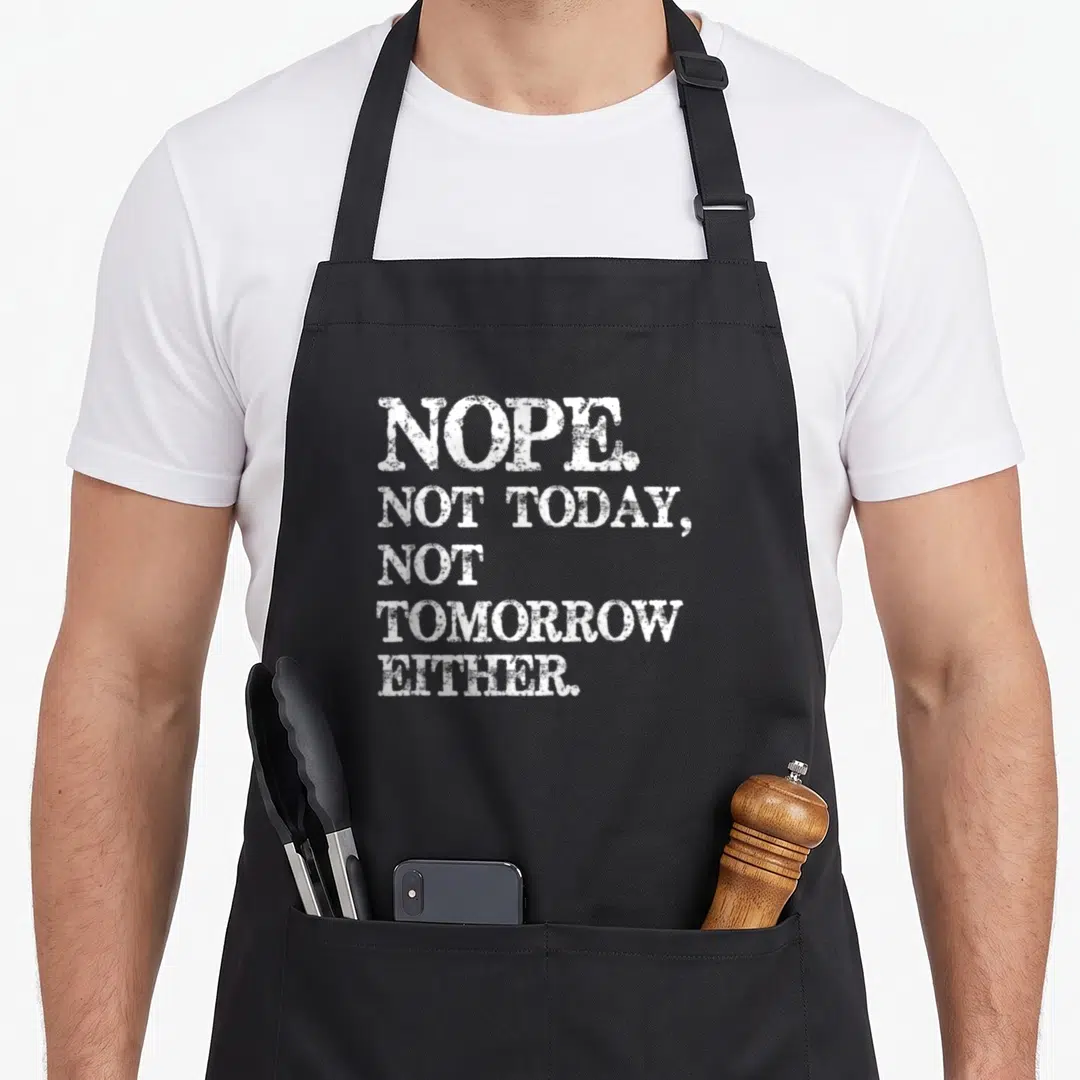 Nope humorous aprons - White stacked text reading NOPE NOT TODAY NOT TOMORROW EITHER on dark background — shown on a black cotton canvas apron against a white background