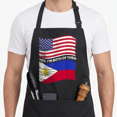 Mixed american flag apron - Distressed USA and Philippines flags with Yes I'm Both Of Them text overlay — shown on a black cotton canvas apron against a white background