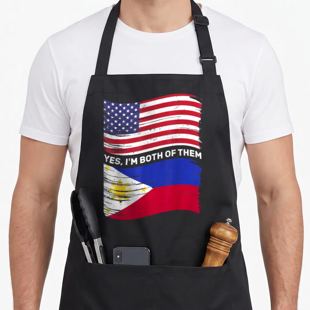 Mixed american flag apron - Distressed USA and Philippines flags with Yes I'm Both Of Them text overlay — shown on a black cotton canvas apron against a white background
