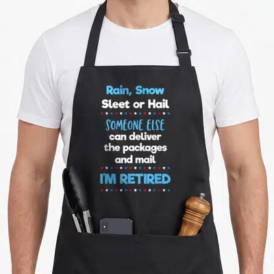 Retired mailman postal aprons - Stacked text reading Rain Snow Sleet Hail Someone Else Can Deliver Packages I'm Retired — shown on a black cotton canvas apron against a white background