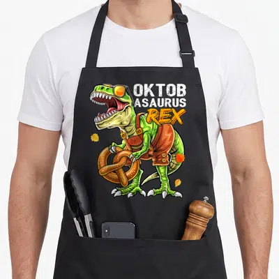 Oktoberfest dinosaur apron - Green T-Rex in brown lederhosen holding pretzel with stacked text OKTOB ASAURUS REX — shown on a black cotton canvas apron against a white background