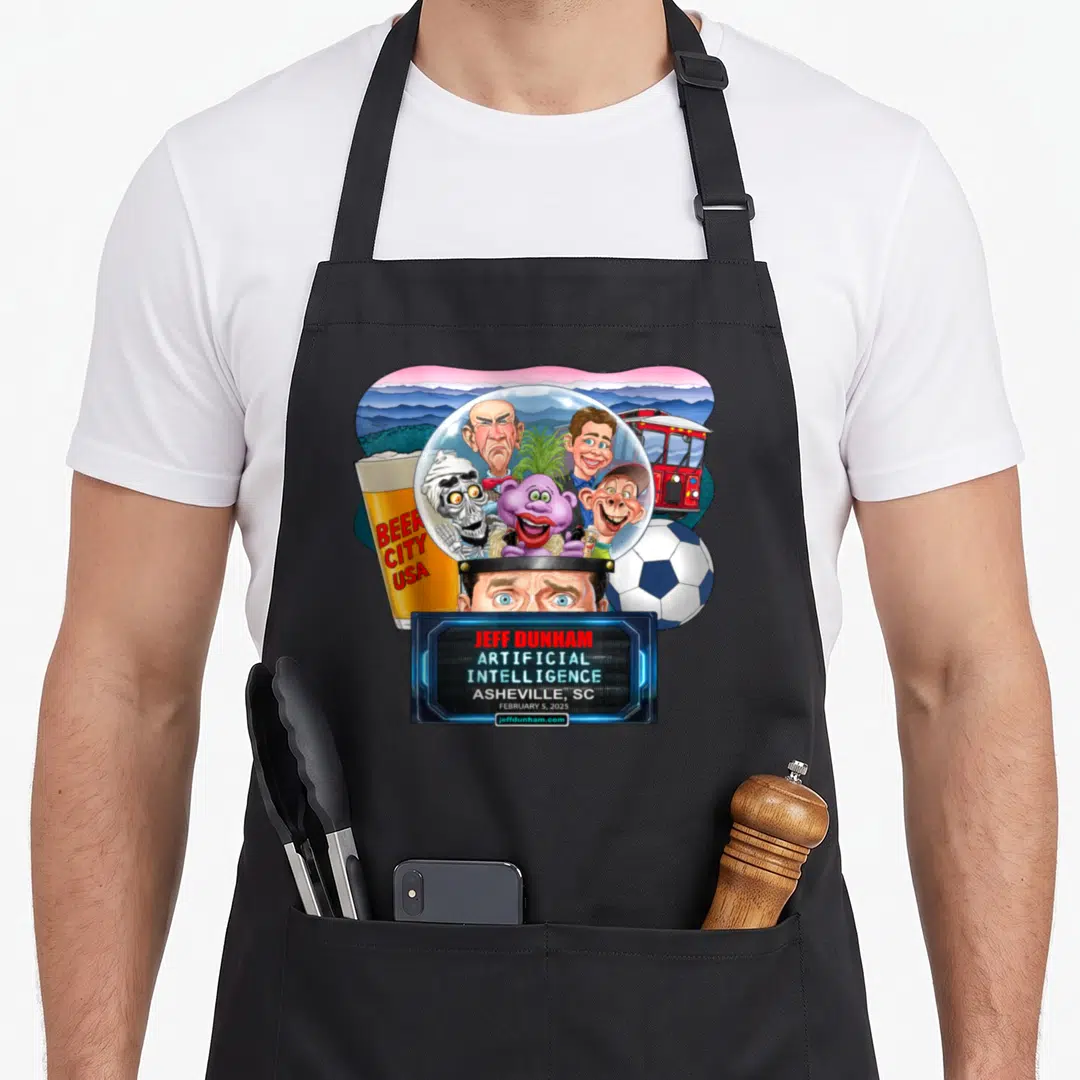 Jeff asheville apron - Jeff Dunham puppets in dome with Beer City glass soccer ball and red trolley cartoon art — shown on a black cotton canvas apron against a white background