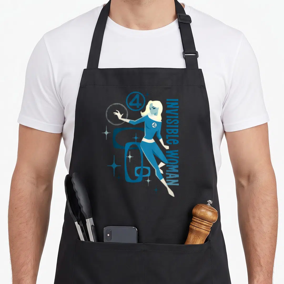 Invisible first steps apron - Retro Invisible Woman illustration with blue suit, stars, and vertical text — shown on a black cotton canvas apron against a white background