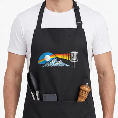 Distressed golf apron - Retro disc golf basket with blue mountains and striped sunburst design — shown on a black cotton canvas apron against a white background
