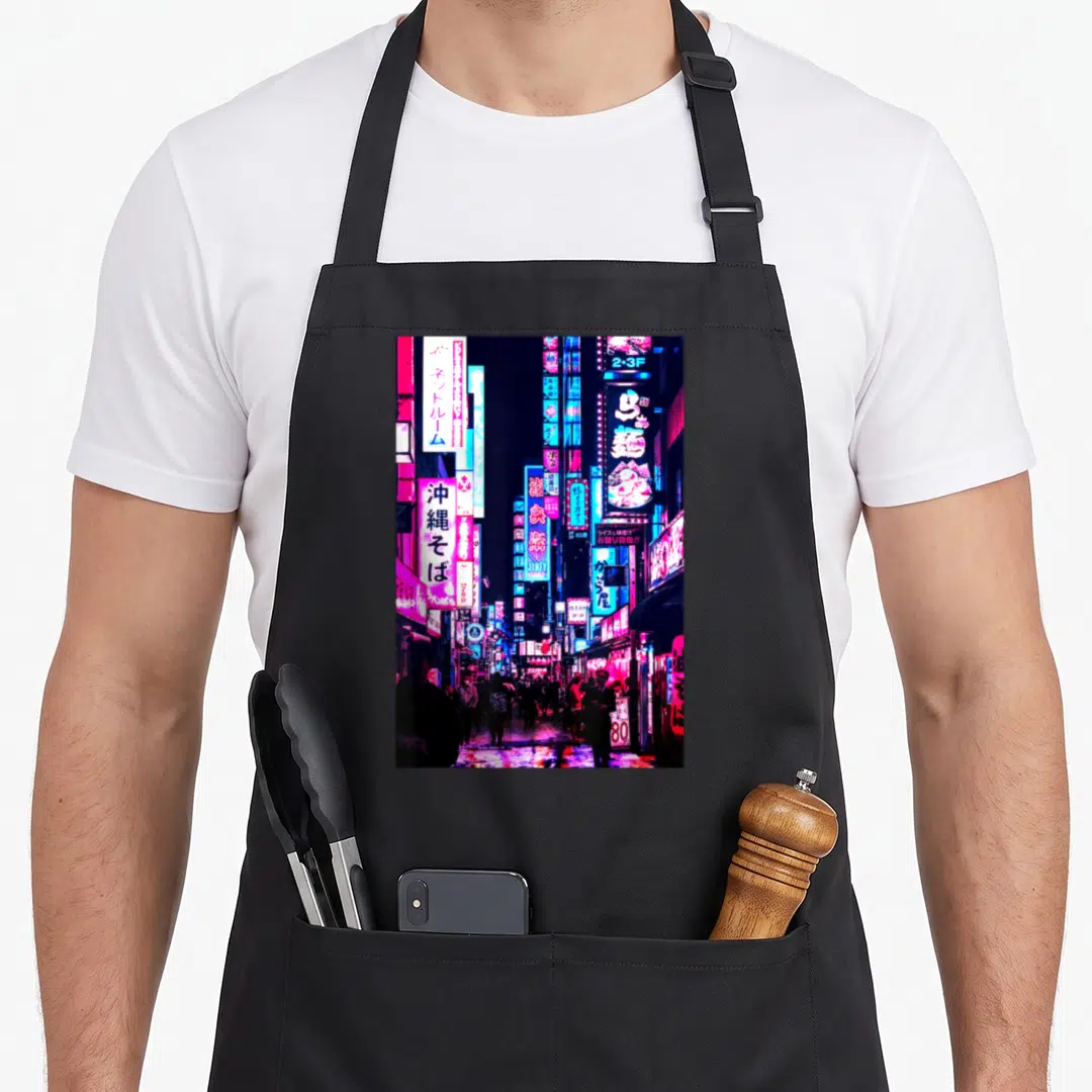 Street japan apron - Vertical neon city street photo with Japanese Kanji signs in magenta blue purple and black — shown on a black cotton canvas apron against a white background