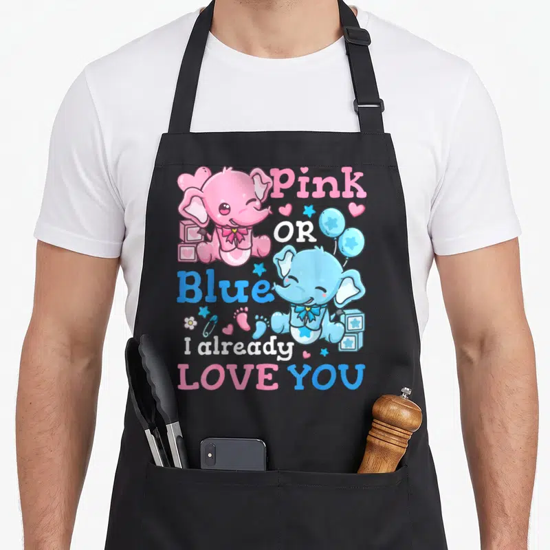 Reveal blue apron or apron - Pink and blue elephants with 'Pink OR Blue I already LOVE YOU' text and baby icons — shown on a black cotton canvas apron against a white background