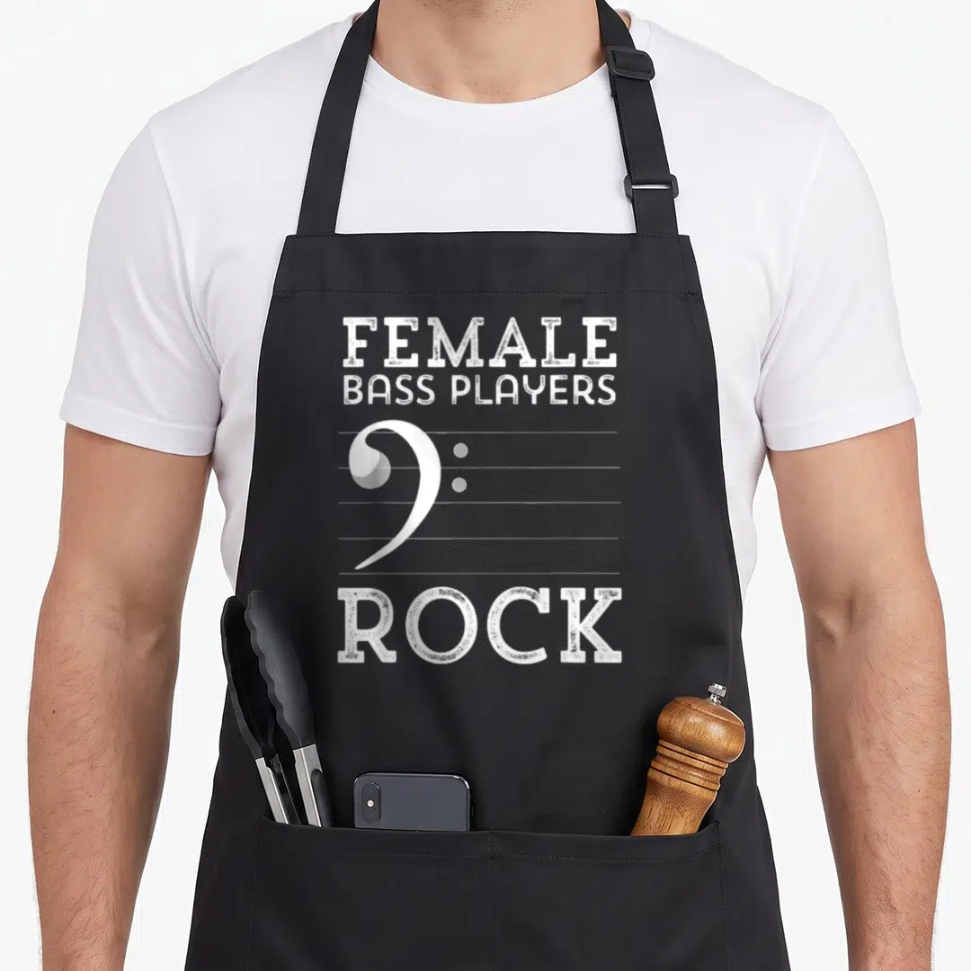 Rock double apron - FEMALE BASS PLAYERS ROCK text with white bass clef on staff lines — shown on a black cotton canvas apron against a white background