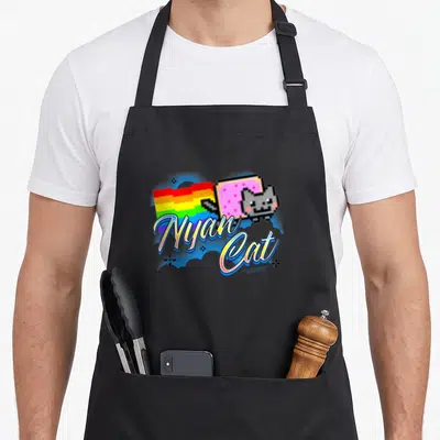 Airbrush cat apron - Pixel Nyan Cat with pink Pop-Tart body, rainbow trail, and script text in blue and pink — shown on a black cotton canvas apron against a white background