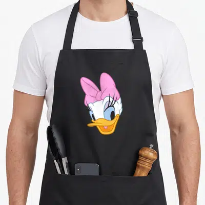 Vintage daisy apron - Centered cartoon duck head with large pink bow and yellow beak — shown on a black cotton canvas apron against a white background