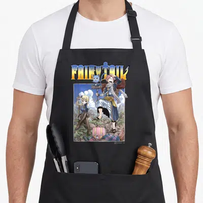 Natsu lucy apron - FAIRY TAIL text above Natsu Dragneel and friends with luggage in mountains — shown on a black cotton canvas apron against a white background
