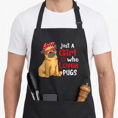 Pug dog showing apron - Cartoon tan pug wearing red glasses and polka dot bow next to stacked text Just A Girl who — shown on a black cotton canvas apron against a white background