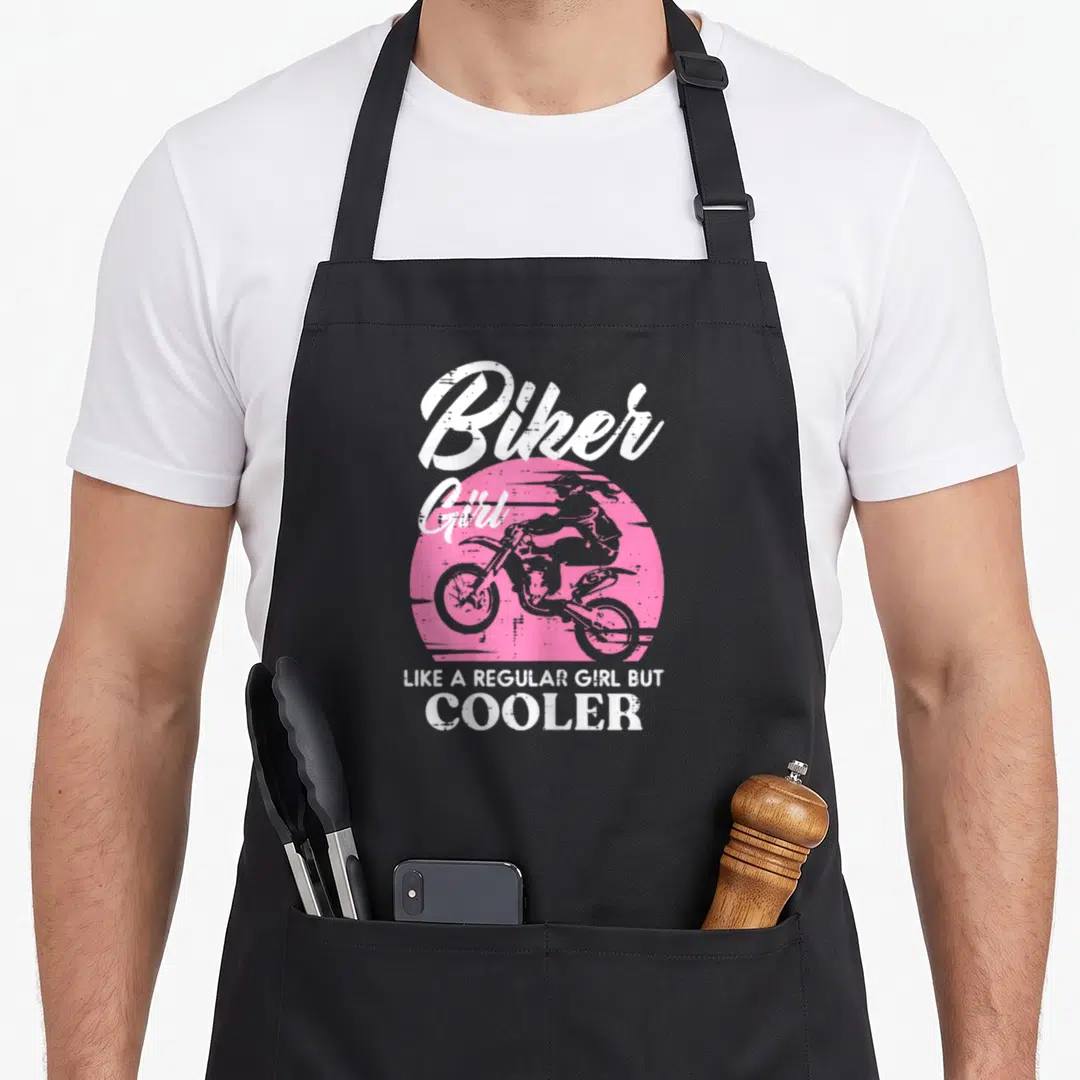 But biker apron - Distressed white text over pink circle containing girl silhouette on motorcycle — shown on a black cotton canvas apron against a white background