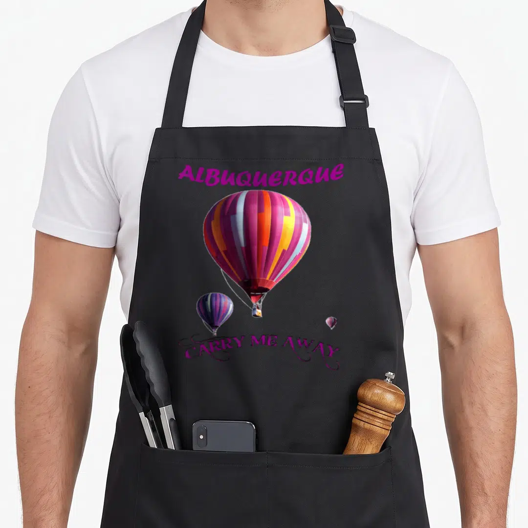 Albuquerque balloon apron - Colorful hot air balloon photo with purple text Albuquerque and Carry Me Away script — shown on a black cotton canvas apron against a white background