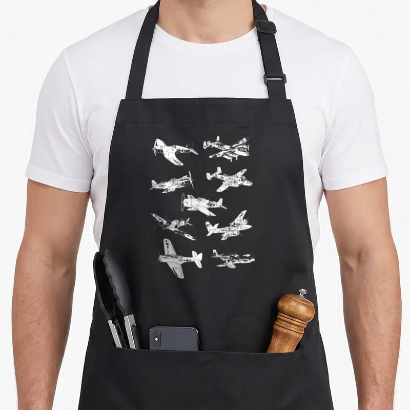 Wwii aircraft apron - Ten white distressed airplanes scattered in various flight angles on grey background — shown on a black cotton canvas apron against a white background