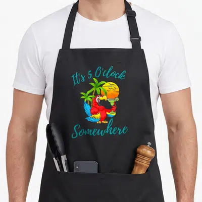 Oclock crazy parrot man apron - Cartoon parrot holding margarita under teal text It's 5 O'clock Somewhere — shown on a black cotton canvas apron against a white background