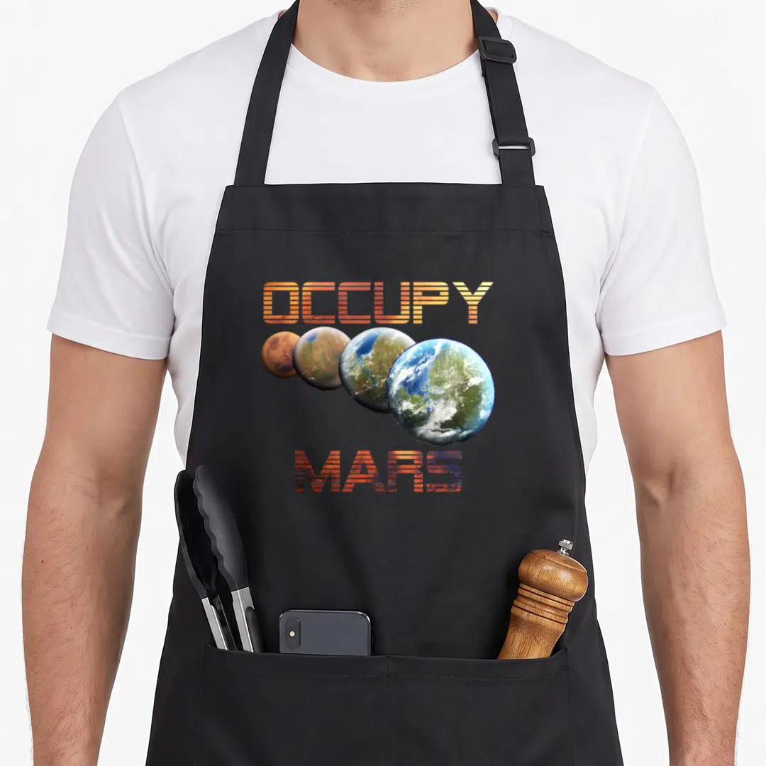 Occupy mars nerd apron - Four planets growing larger in orange blue green and red under striped text — shown on a black cotton canvas apron against a white background