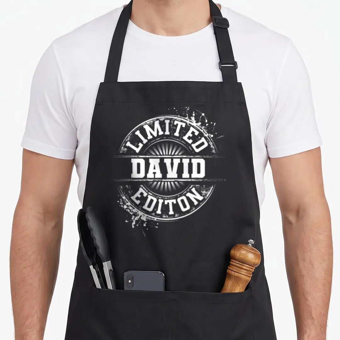 David family reunion aprons - White distressed circular stamp reading LIMITED DAVID EDITON with paint splatters — shown on a black cotton canvas apron against a white background