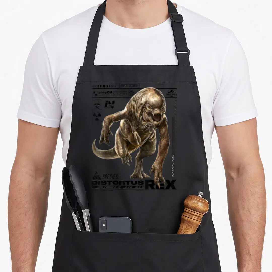 Rebirth t-rex apron - Realistic brown monster with Distortus Rex text and biohazard symbols on grey background — shown on a black cotton canvas apron against a white background