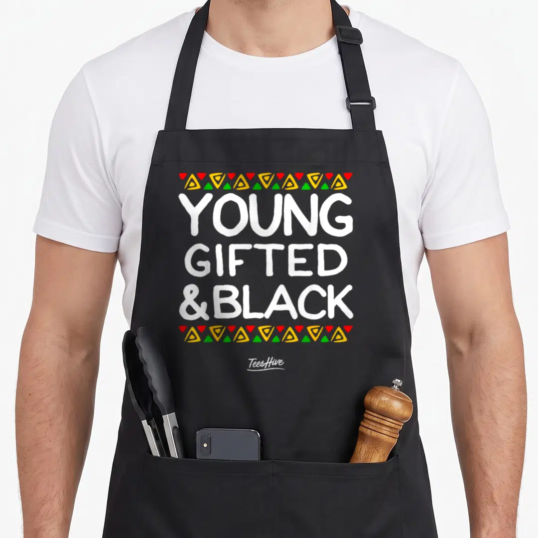 Young african american aprons - YOUNG GIFTED &BLACK text bordered by red yellow green triangles — shown on a black cotton canvas apron against a white background